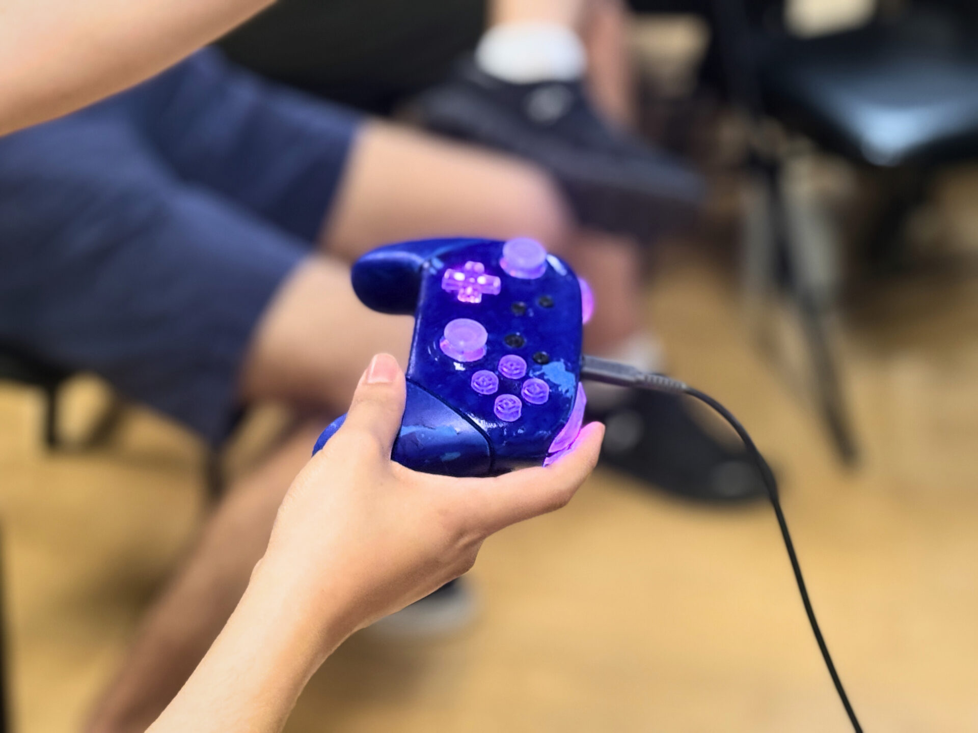 Hand holding a game controller at EM's game development club